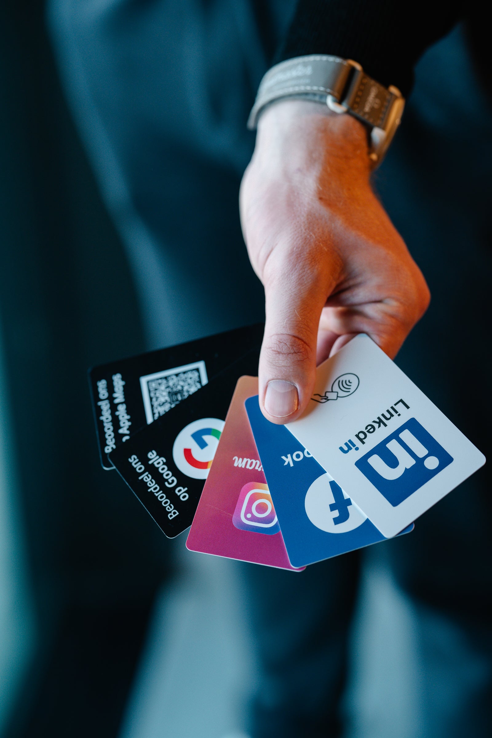 Hand holding social media platform cards with blurred background NFC-Cards