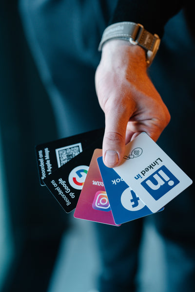 Hand holding social media platform cards with blurred background NFC-Cards